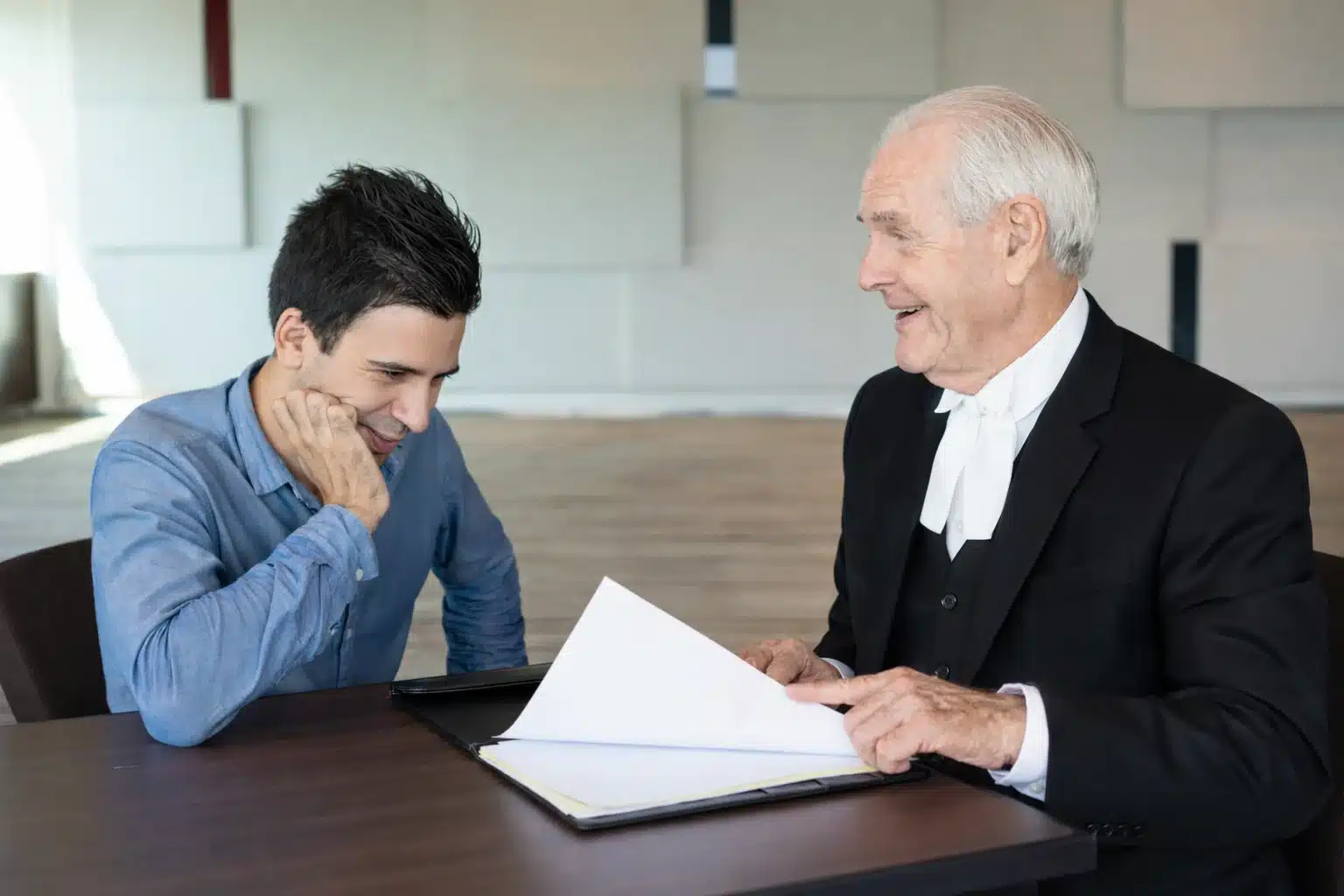 Personal injury lawyer reviewing legal documents with client during settlement consultation